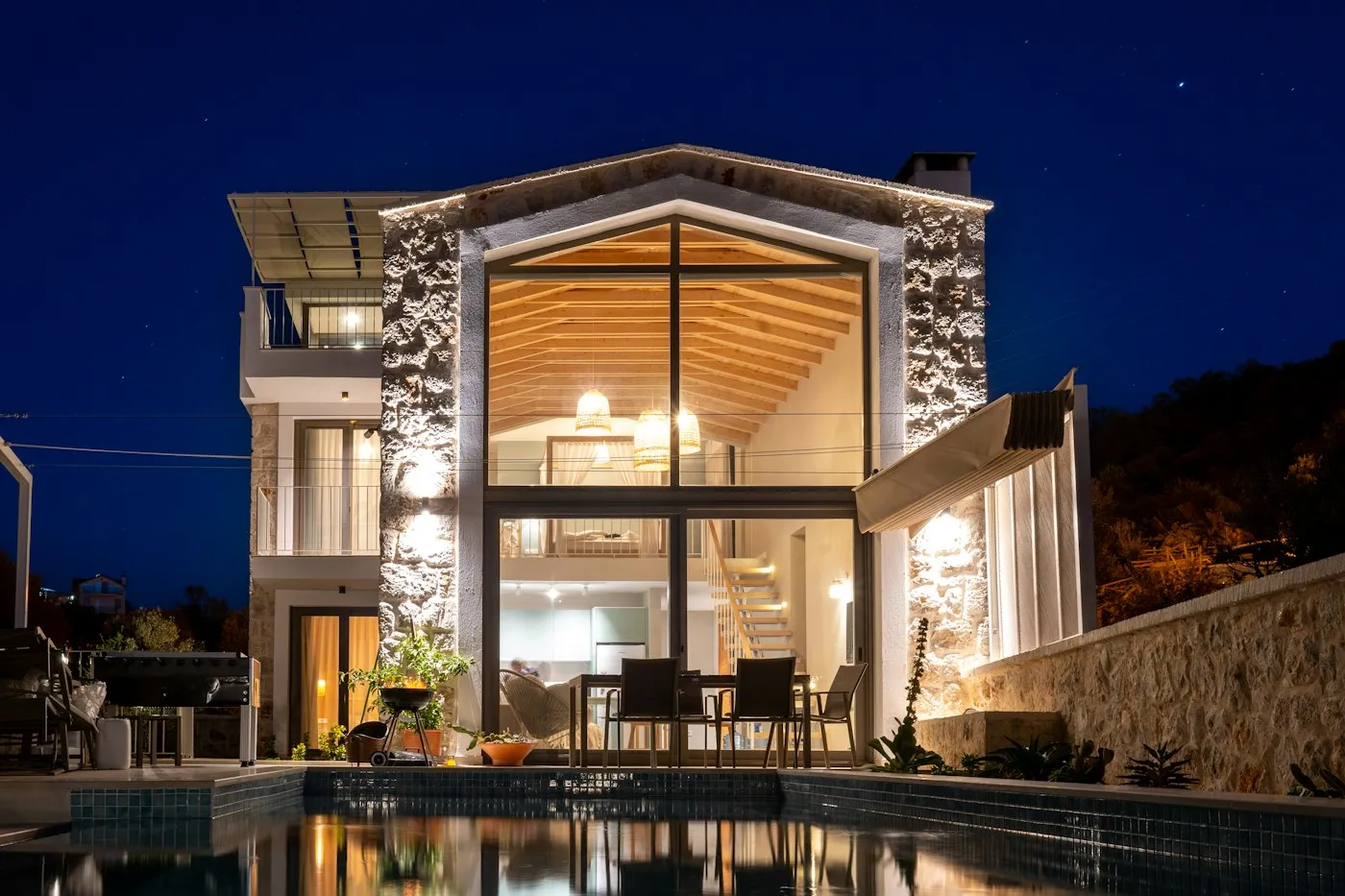 Gece aydınlatılmış taş villa ve havuz